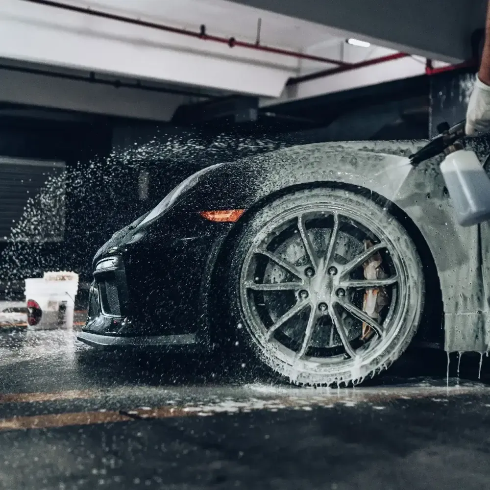 Porsche getting foam cannon sprayed onto it. It is used as a banner for services in auto detailing